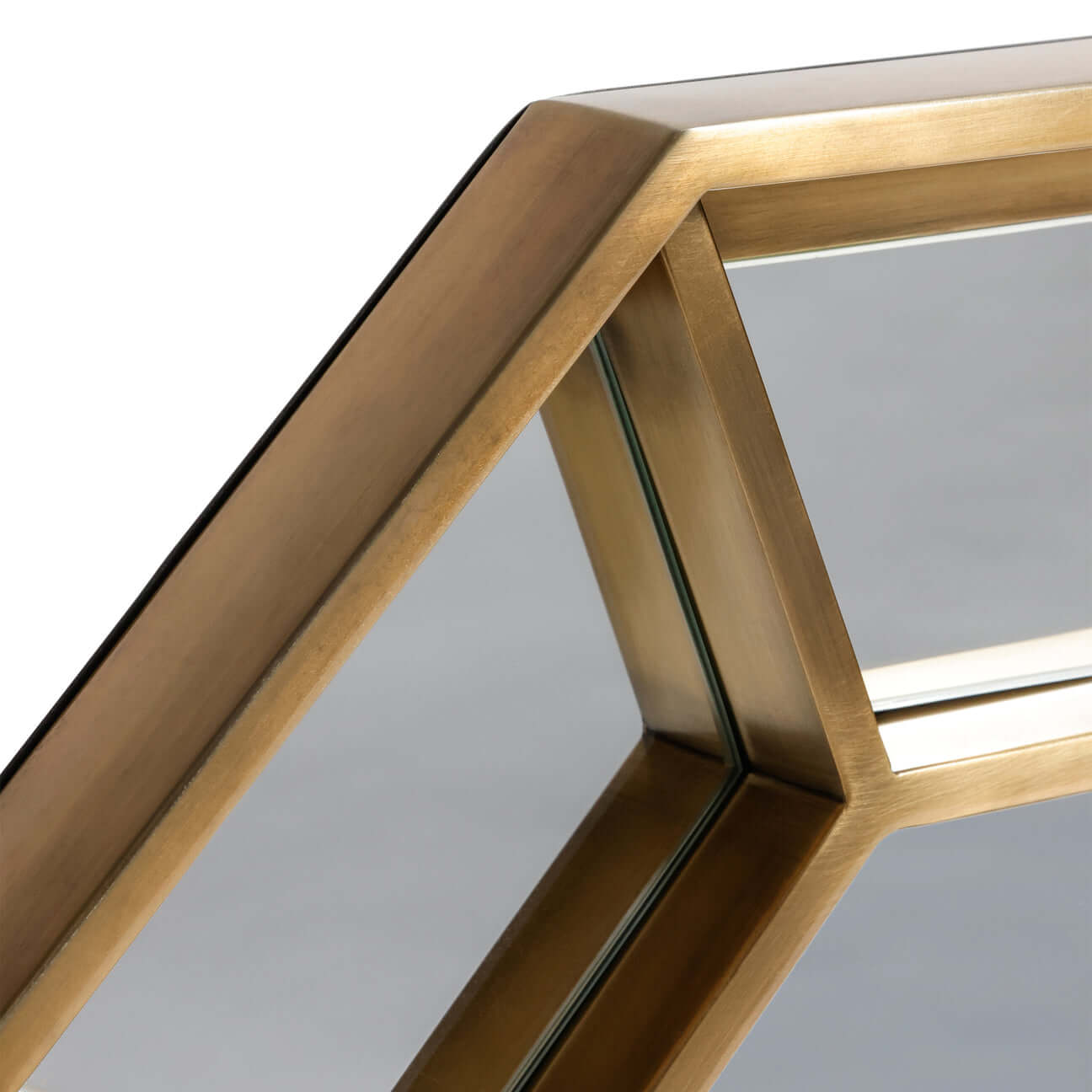 Detail of Celesta Hex Wall Mirror showcasing the brushed brass geometric frame and glass panels.
