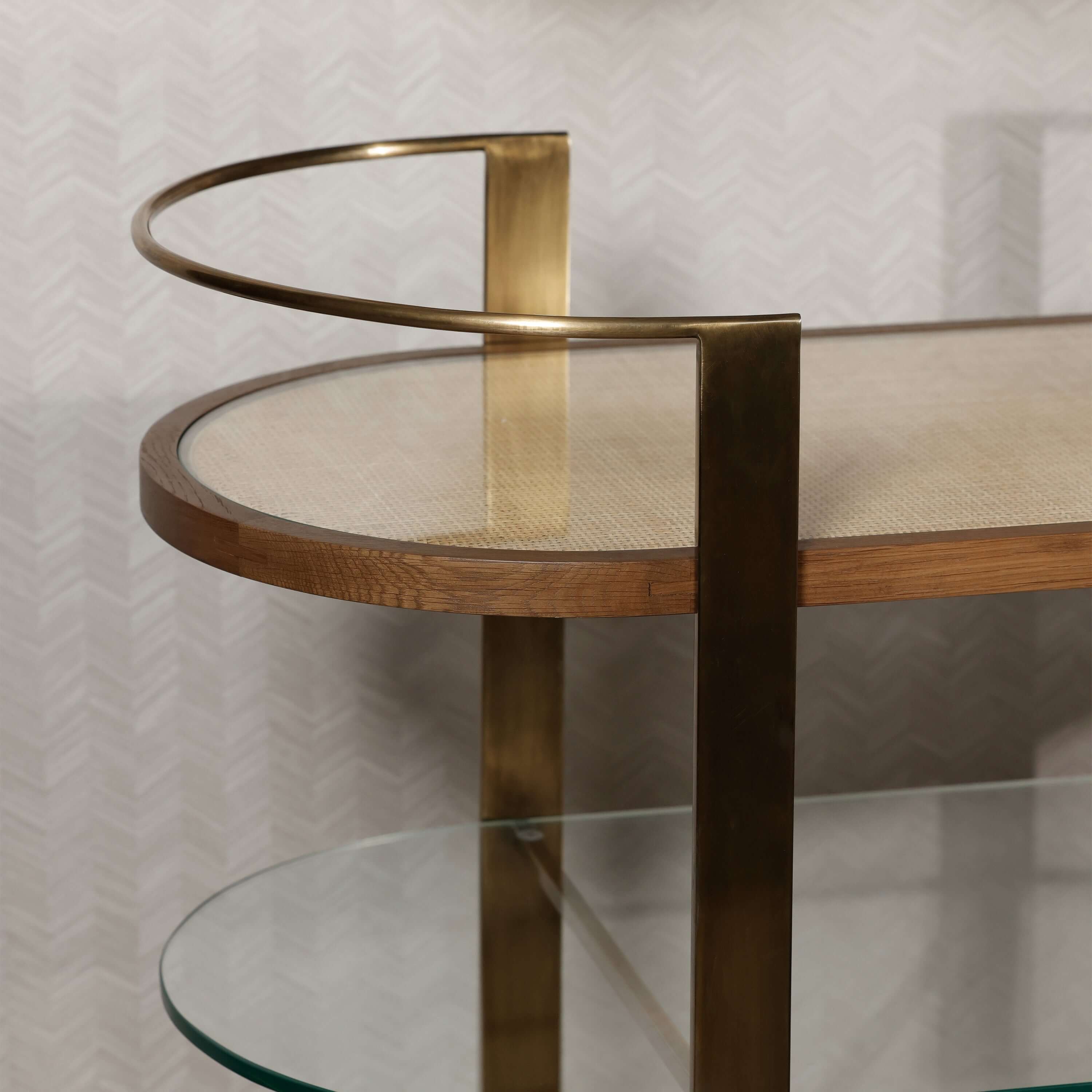 Sloane Oak Wood Oval Bar Cart with antique brass-finished steel frame and clear glass top.