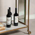 Soho Marble Bar Cart featuring brass handles and wine bottles on a stylish white marble surface.