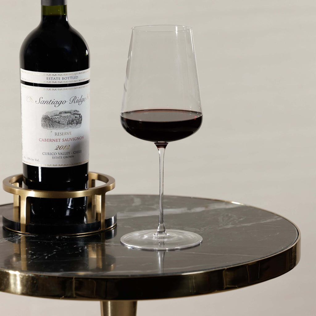 A glass of red wine beside a bottle of Santiago Ridge Cabernet Sauvignon on the Nomad Table.