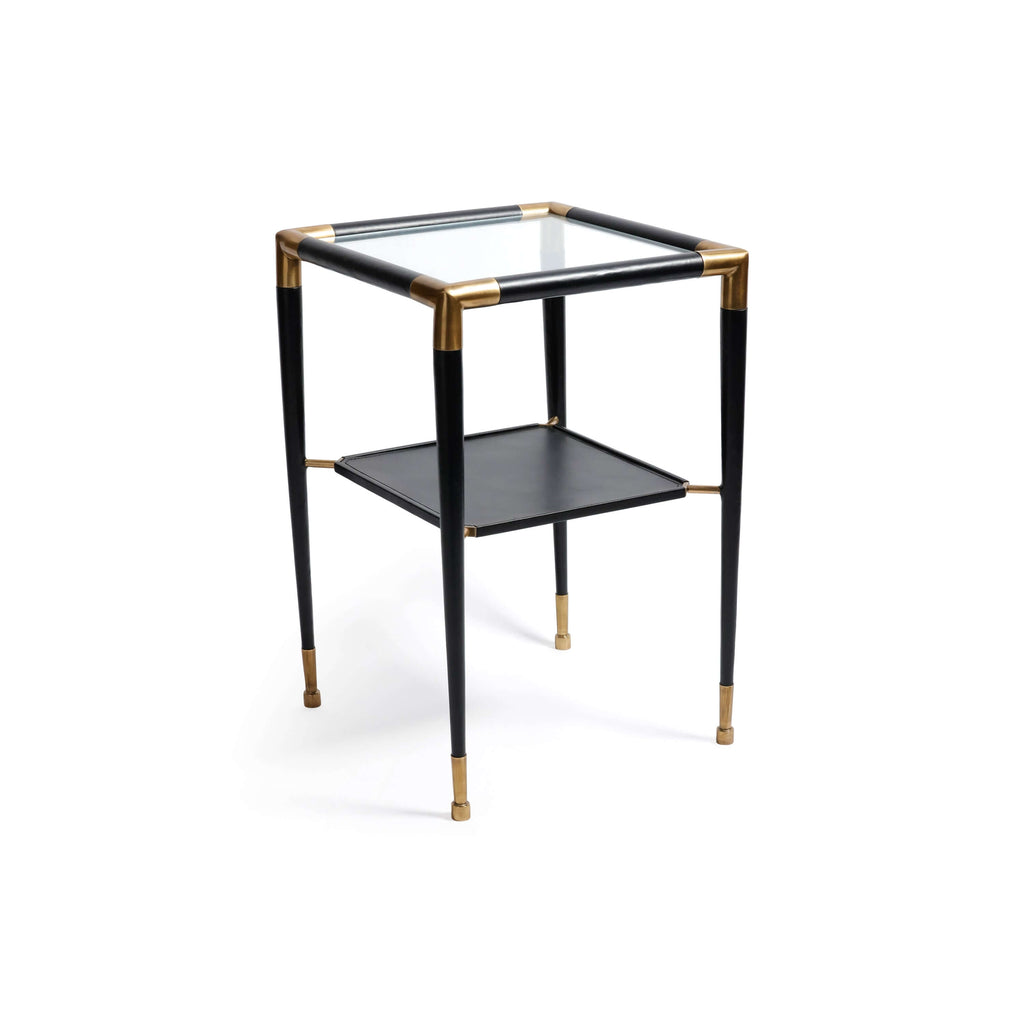 Peninsula Leather Side Table with brass joints and glass top, featuring a two-tier design and matte black finish.