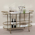 Lido Console Bar Cart featuring champagne brass frame and decorative glassware.