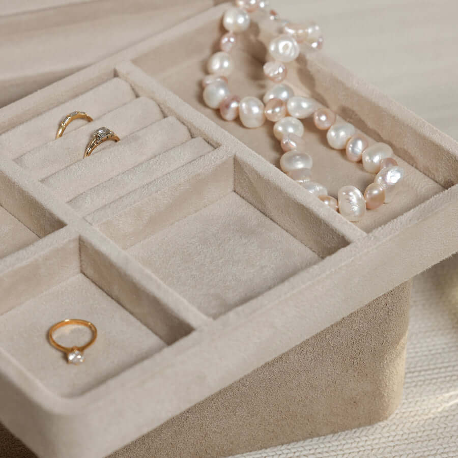 Interior view of Linea Suede Jewelry Box showcasing compartments and jewelry pieces.