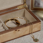 Inside view of the Linea Heritage Burl Veneer Jewelry Box showcasing gold jewelry pieces.