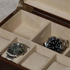 Interior view of Linea Madrona Burl Veneer Jewelry Box with two luxury watches in suede-lined compartments.