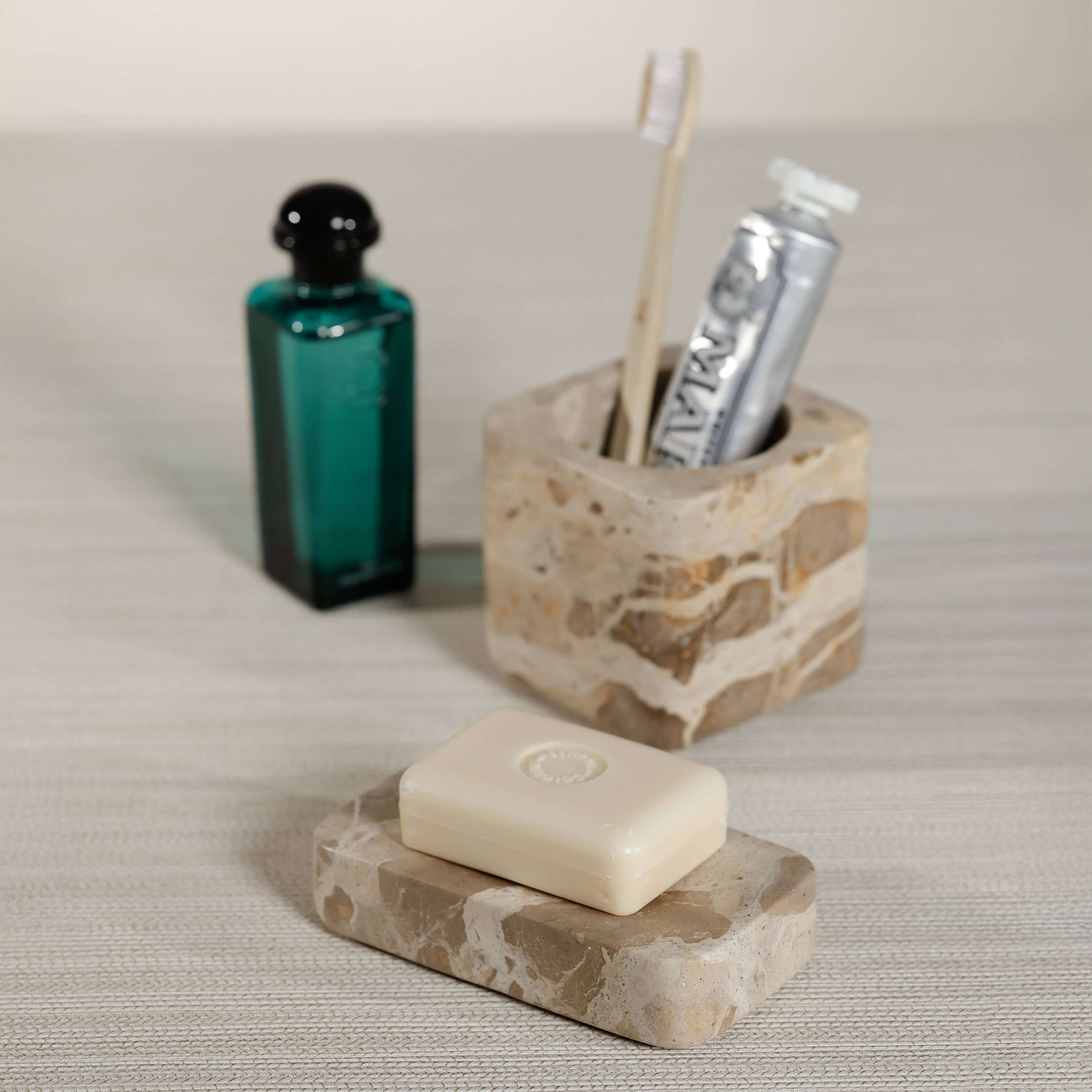 Crema Fossil Marble Bath Collection accessories including soap dish and toothbrush holder on a neutral countertop.