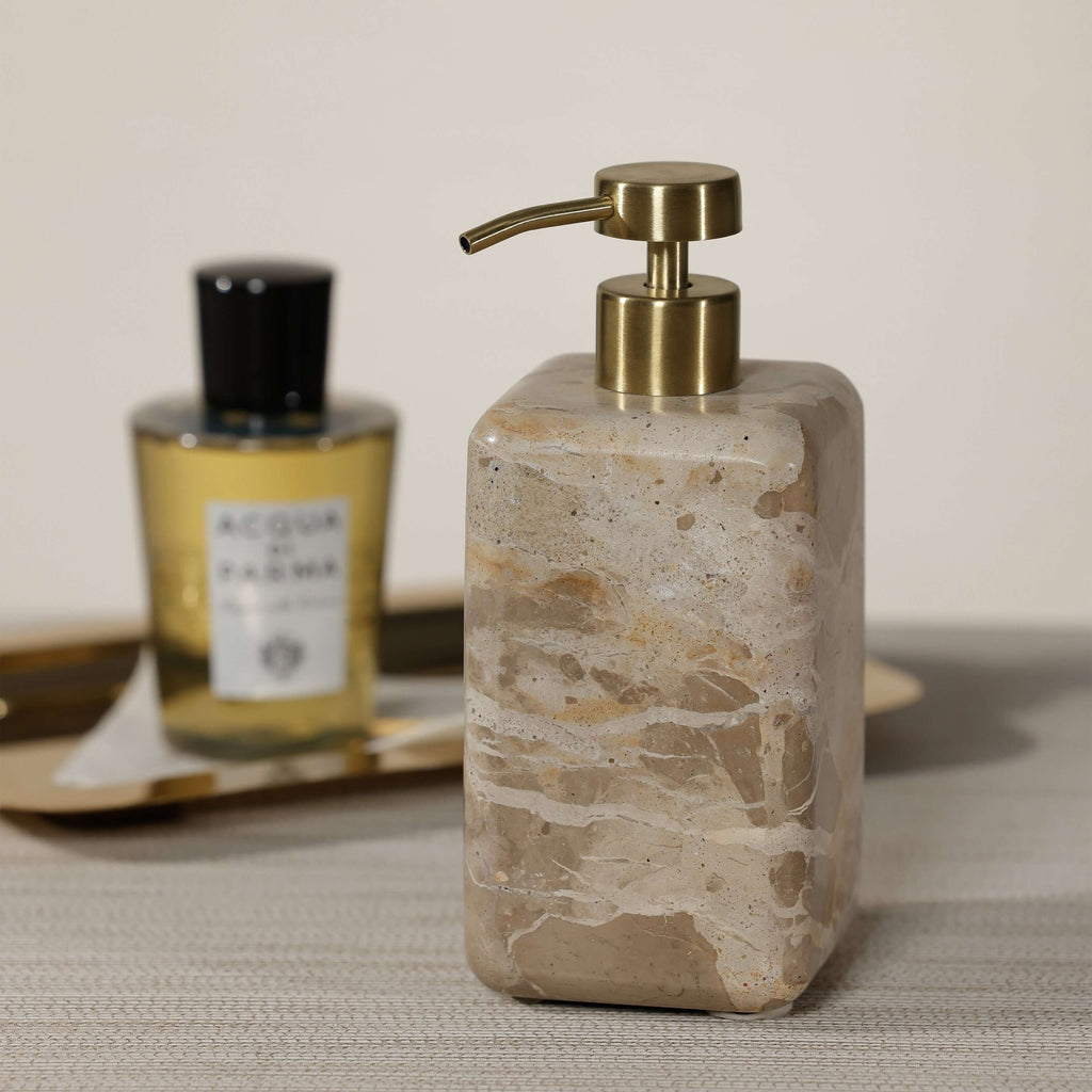 Crema Fossil Marble Bath Collection soap dispenser with a polished stone finish and gold pump on a stylish countertop.