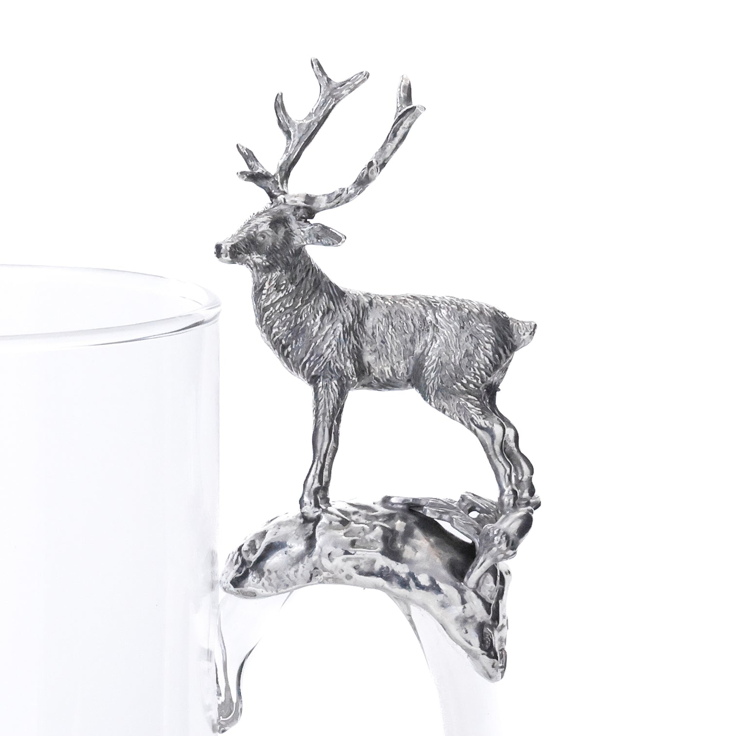 Silver deer ornament on a clear glass with a white background