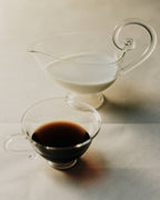 Petite Tasse, Clear (Set of 2) with a sleek teacup and milk pitcher on a light background.
