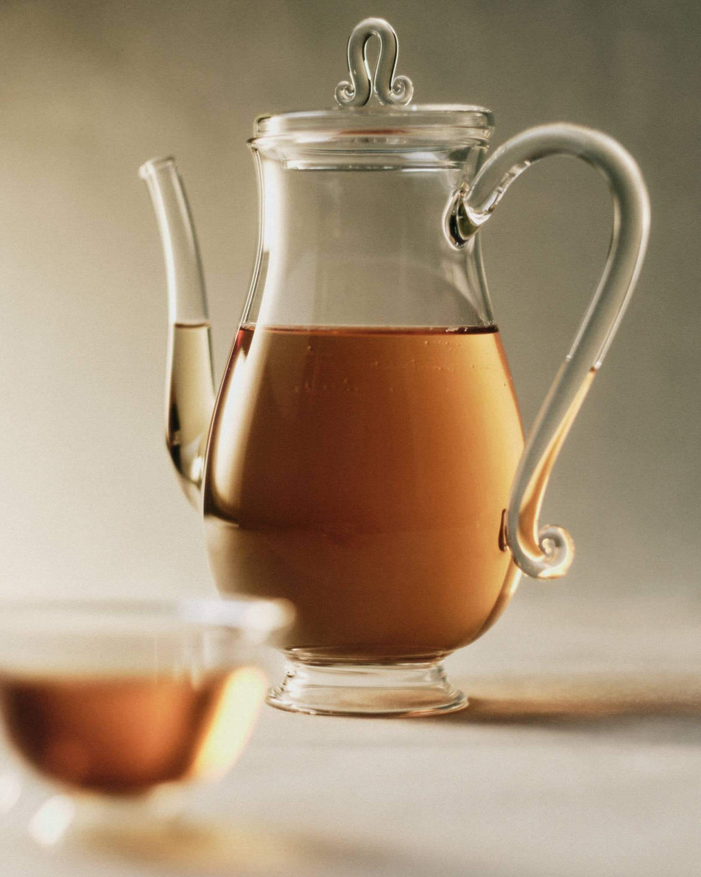 Bell Pot, Clear with tea, showcasing a curvy silhouette and curling glass details for elegant dining.